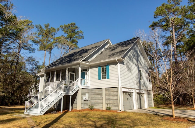 view of front of house with driveway, a porch, stairway, a front yard, and a garage