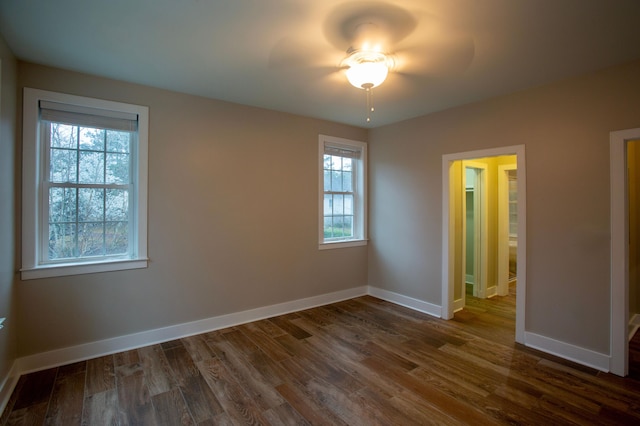 unfurnished bedroom featuring baseboards and dark wood-style flooring