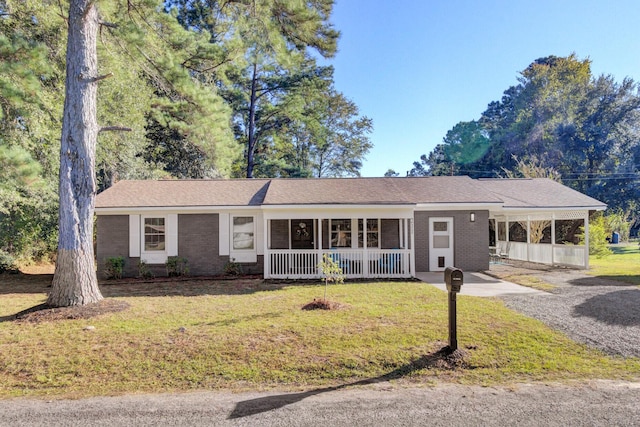 ranch-style home featuring a front yard, a porch, and a carport