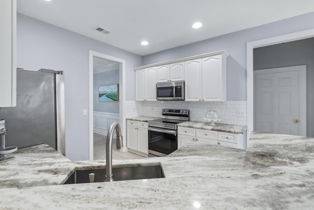 1250 White Tail Path, Charleston, SC 29414 - kitchen with stainless steel appliances, light stone countertops, a sink, white cabinetry, and backsplash