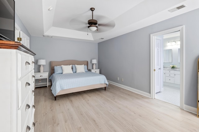 1250 White Tail Path, Charleston, SC 29414 - bedroom featuring a raised ceiling, light wood-type flooring, baseboards, ensuite bath, and a ceiling fan