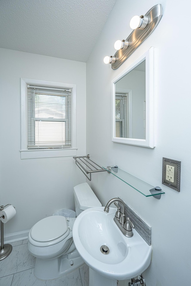 bathroom with sink, toilet, and a textured ceiling