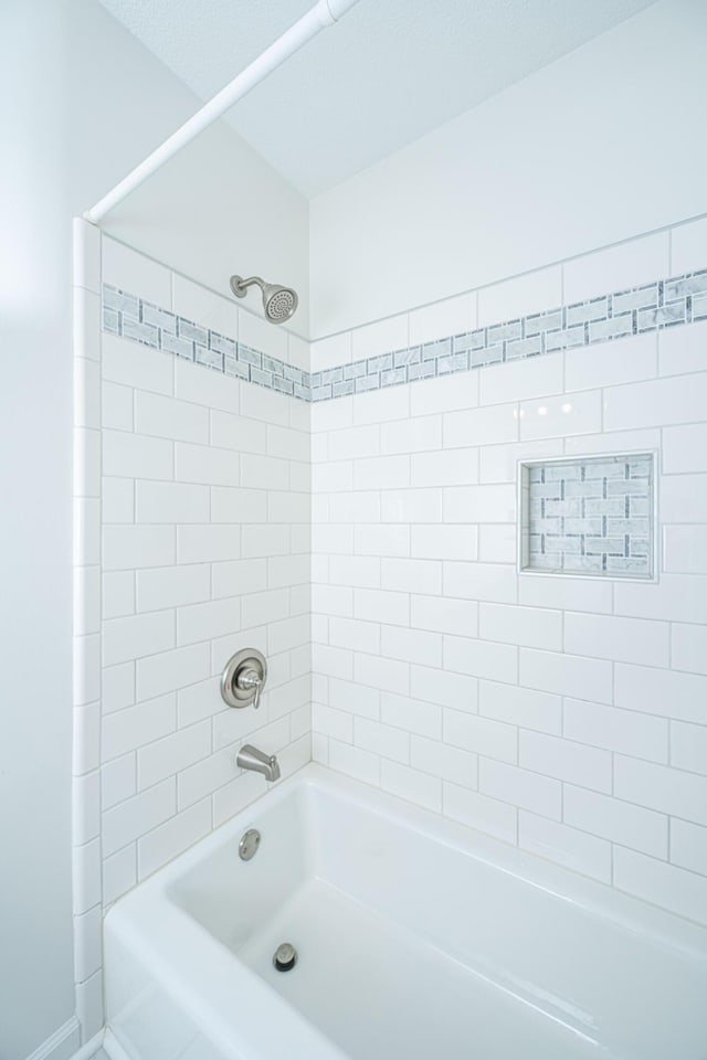 bathroom with tiled shower / bath combo