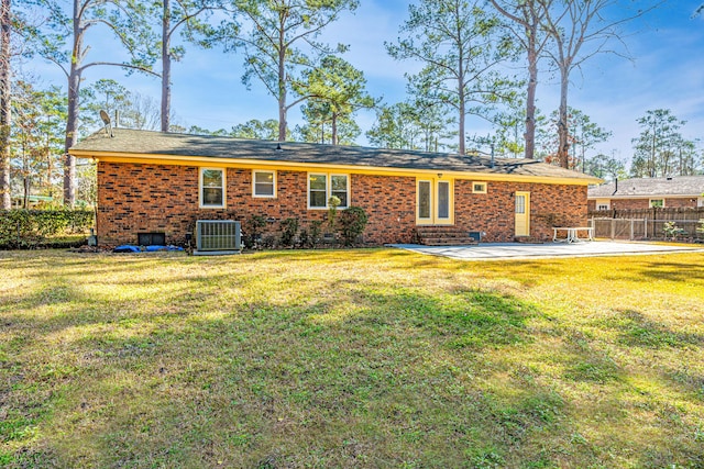 back of house with central AC, a yard, and a patio area