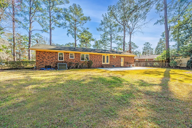 rear view of house with a patio, central AC, and a lawn
