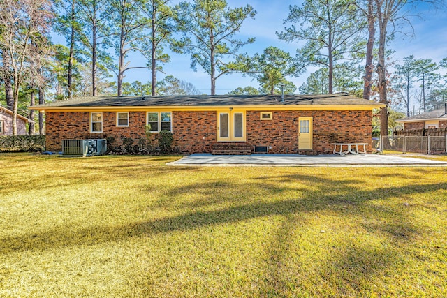 rear view of property featuring a yard, central AC, and a patio area