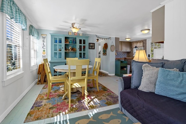 dining room featuring ornamental molding, ceiling fan, and light wood-type flooring