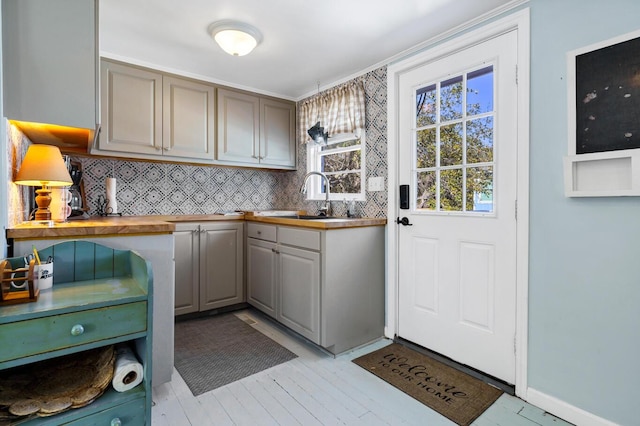 kitchen featuring tasteful backsplash, sink, gray cabinets, and wood counters