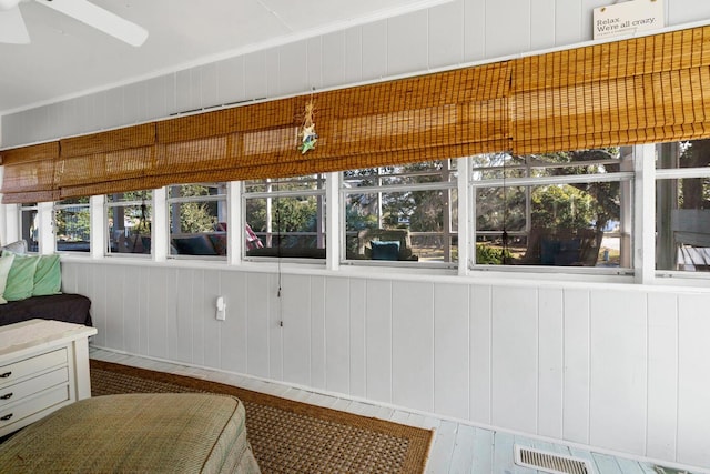 unfurnished sunroom featuring ceiling fan