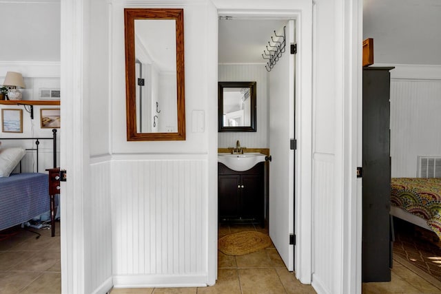 corridor with light tile patterned floors and sink