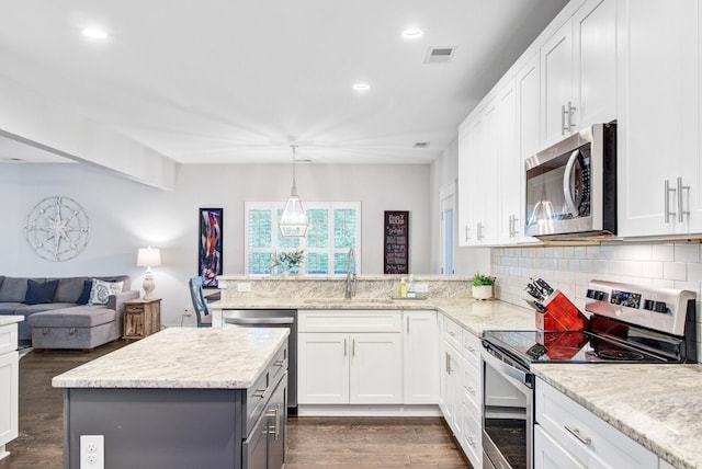 6190 Button Bush Dr, Ravenel, SC 29470 - kitchen with stainless steel appliances, a sink, dark wood-style floors, open floor plan, and white cabinets