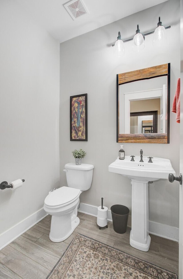 6190 Button Bush Dr, Ravenel, SC 29470 - bathroom featuring toilet, wood finished floors, baseboards, a fireplace, and a sink