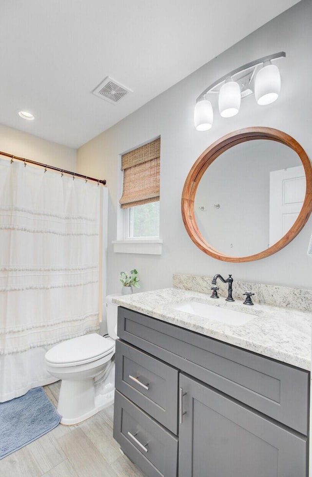 6190 Button Bush Dr, Ravenel, SC 29470 - bathroom with vanity, toilet, wood finished floors, and curtained shower