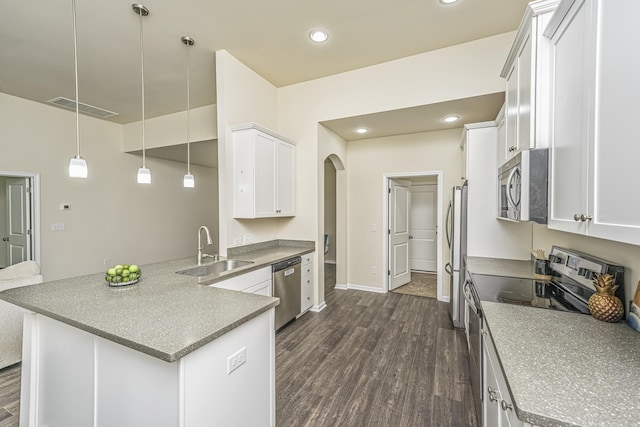 kitchen featuring visible vents, arched walkways, a sink, dark wood-style floors, and stainless steel appliances