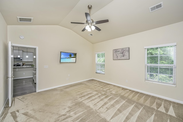 unfurnished bedroom with vaulted ceiling, baseboards, light colored carpet, and visible vents
