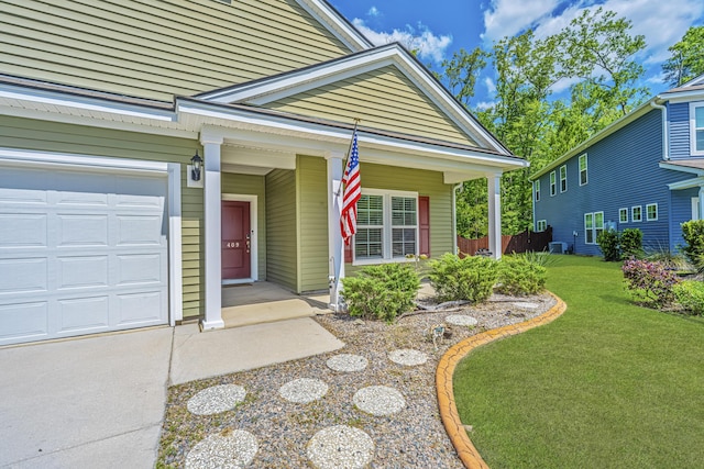 doorway to property featuring a lawn, a porch, and a garage
