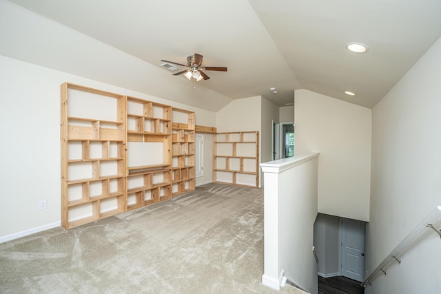 interior space with visible vents, carpet, a ceiling fan, baseboards, and vaulted ceiling