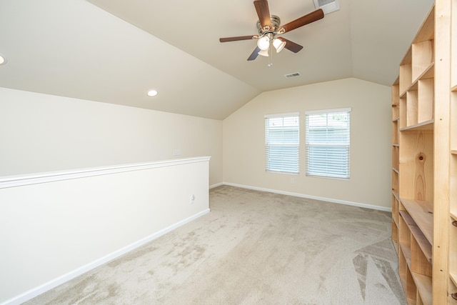 bonus room with ceiling fan, light colored carpet, visible vents, vaulted ceiling, and baseboards