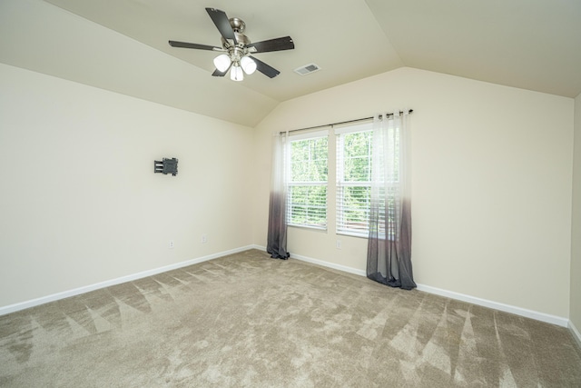 spare room featuring visible vents, carpet floors, lofted ceiling, baseboards, and ceiling fan