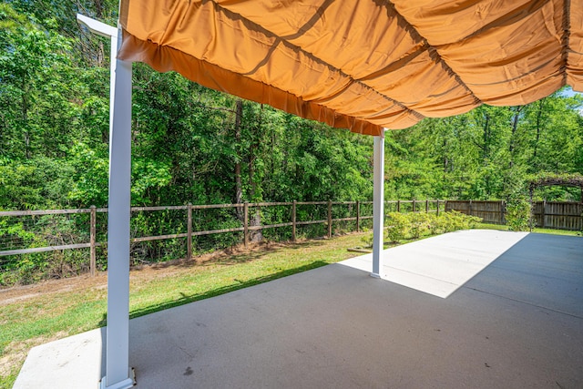 view of patio / terrace featuring a fenced backyard and a wooded view
