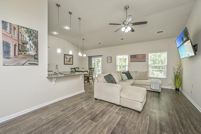 living room featuring dark wood-style flooring, vaulted ceiling, and plenty of natural light