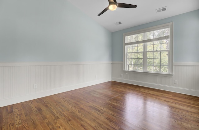 unfurnished room with visible vents, wainscoting, and wood finished floors