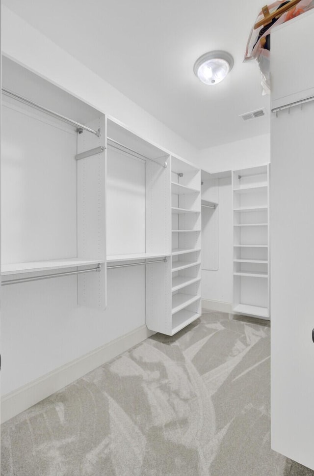 walk in closet with visible vents and carpet flooring