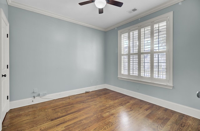 unfurnished room featuring wood finished floors, a ceiling fan, visible vents, baseboards, and crown molding