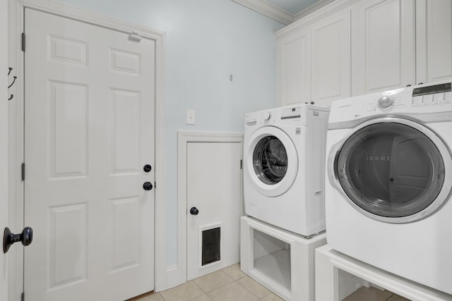 laundry area featuring light tile patterned flooring, cabinet space, crown molding, and separate washer and dryer