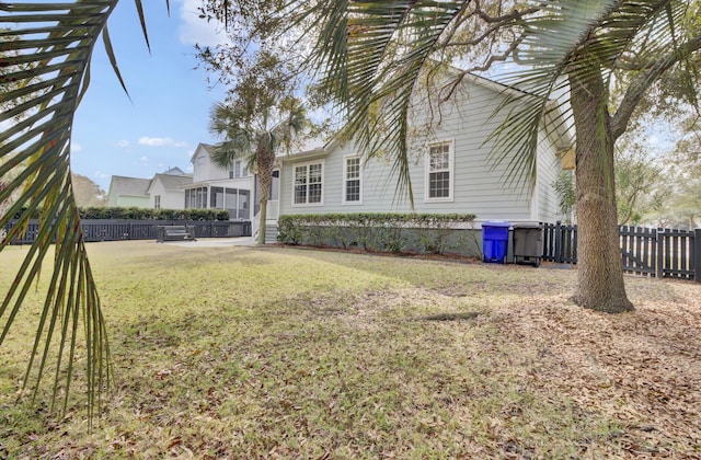 view of yard featuring fence and a sunroom