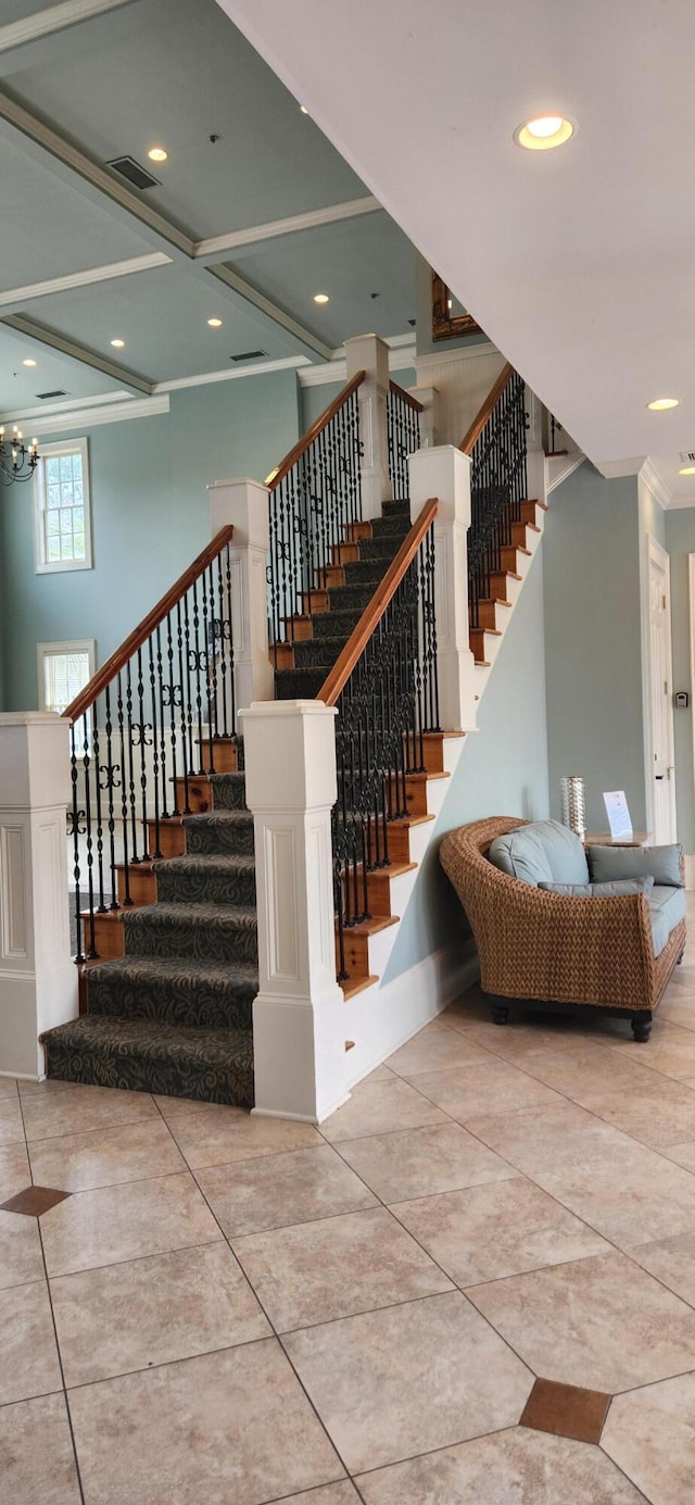 staircase with visible vents, crown molding, recessed lighting, an inviting chandelier, and a towering ceiling