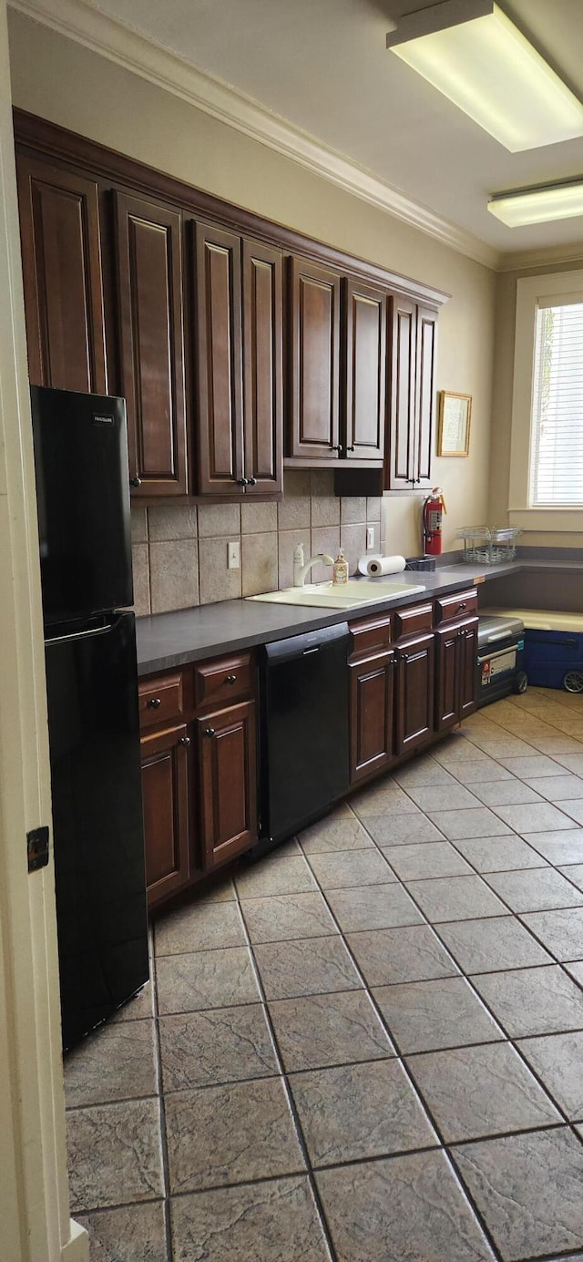 kitchen featuring dark brown cabinetry, dishwasher, ornamental molding, decorative backsplash, and freestanding refrigerator