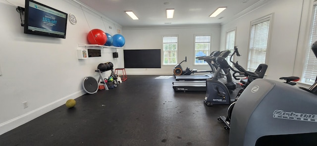 exercise room featuring baseboards and ornamental molding