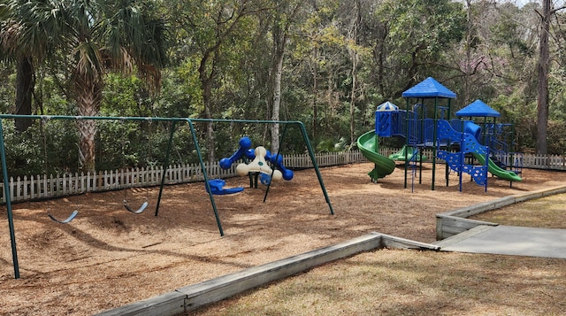 community play area featuring fence and a forest view