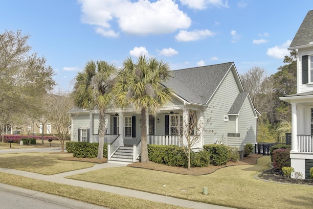 view of front of property featuring a porch, a front yard, and roof with shingles