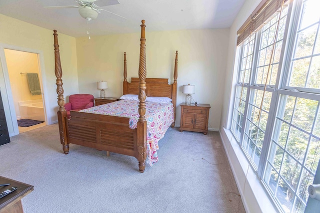 bedroom with ceiling fan, connected bathroom, and light carpet