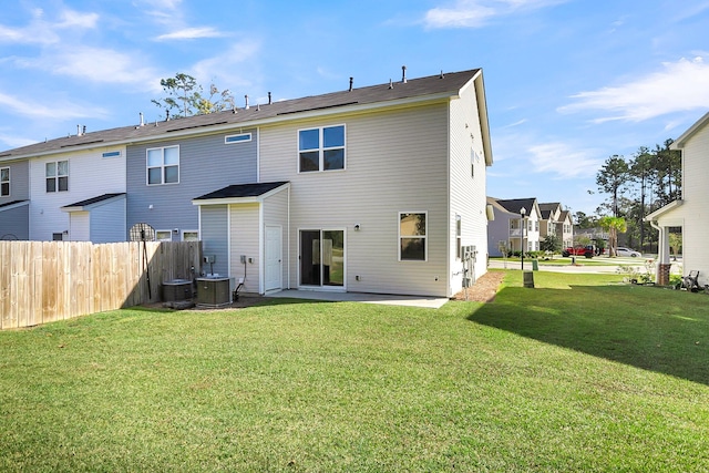 back of property with a patio, central AC, and a lawn