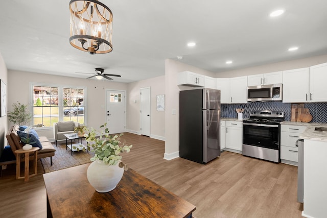 105 Bermuda Ct, Summerville, SC 29485 - kitchen with stainless steel appliances, backsplash, ceiling fan, white cabinets, and light wood finished floors
