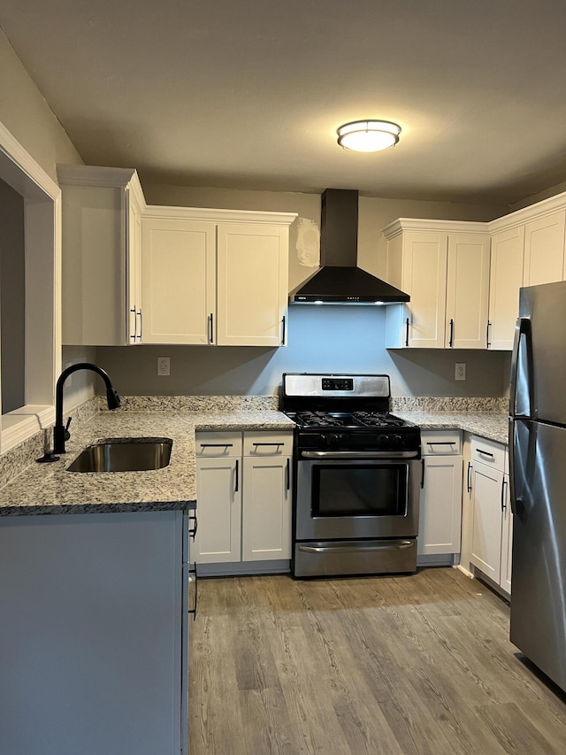 105 Bermuda Ct, Summerville, SC 29485 - kitchen featuring wall chimney exhaust hood, gas stove, freestanding refrigerator, a sink, and light wood-style flooring