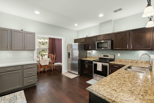 kitchen with backsplash, visible vents, appliances with stainless steel finishes, and a sink