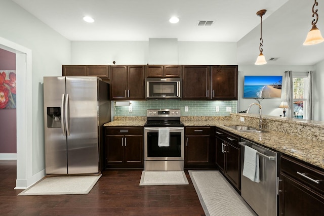 kitchen with decorative backsplash, dark wood-type flooring, appliances with stainless steel finishes, and a sink