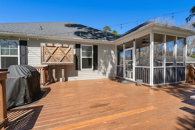 wooden deck featuring a grill and a sunroom