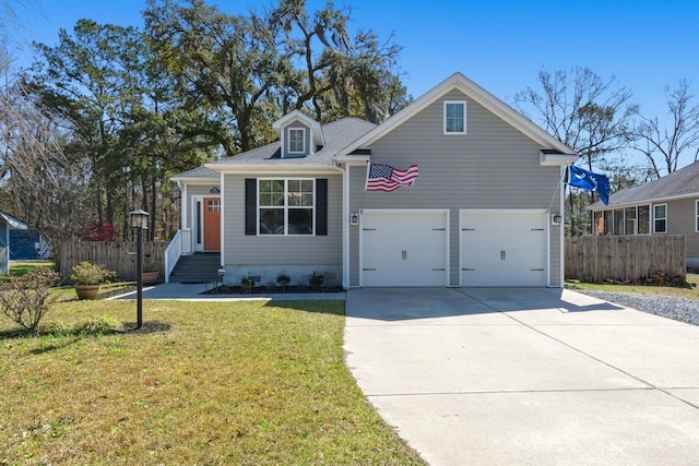 view of front of home with entry steps, concrete driveway, fence, and a front lawn