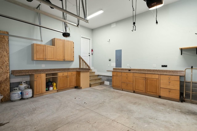 garage featuring electric panel and a garage door opener