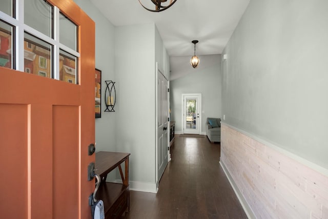 hallway with baseboards, dark wood finished floors, and vaulted ceiling