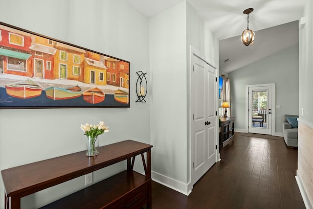 corridor with baseboards, lofted ceiling, and dark wood finished floors