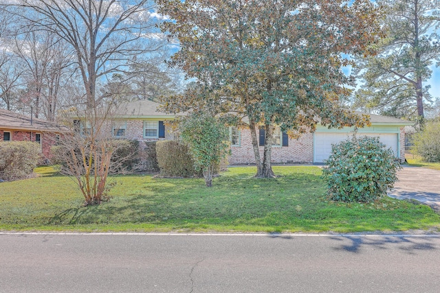 view of property hidden behind natural elements featuring driveway, a front lawn, an attached garage, and brick siding