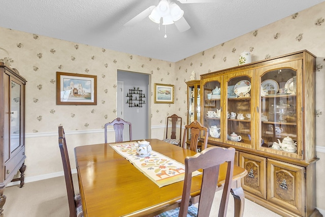 dining room featuring light carpet, a textured ceiling, and ceiling fan