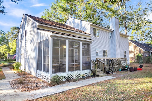 back of property featuring a wooden deck and a sunroom