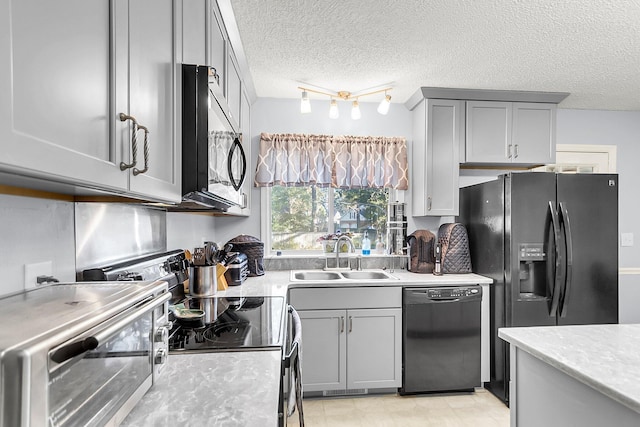 kitchen featuring a textured ceiling, sink, gray cabinets, and black appliances